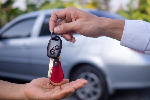 The car salesman and the key to the new owner. photo