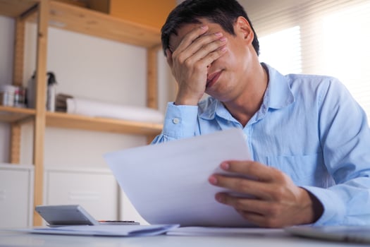 A business person sitting in the head Stressed with debt Bill of income and expenses that are held in hand. photo