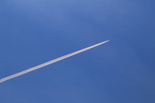 A plane and vapor trails in the sky photo
