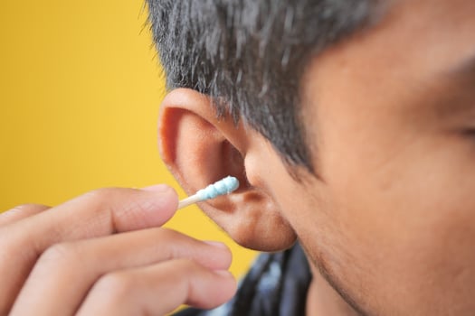 men using ear cotton bar close up photo