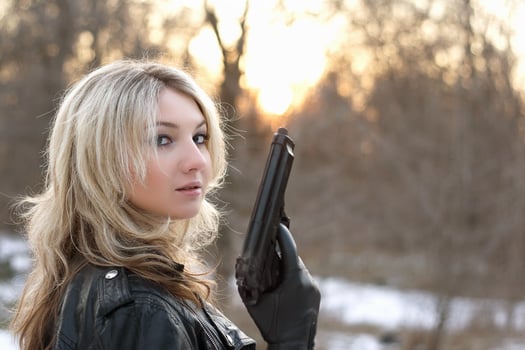 Provocative young woman with a gun photo