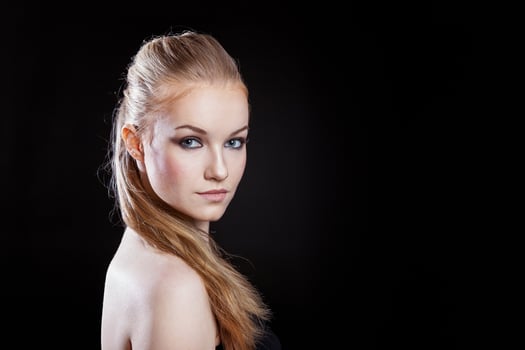Beauty fashion model girl with long healthy smooth straight hair ponytail hairstyle on black background. Smiling pretty woman looking camera. Perfect Fresh Skin Portrait. Youth and Skin Care Concept. photo