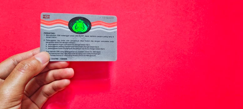 Man holding SIM card or driving license isolated on a red background. photo