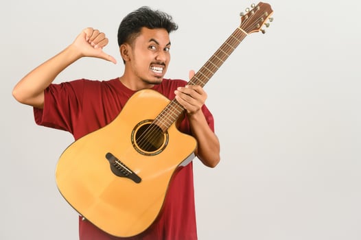 Portrait of Young Asian man in red t-shirt with an acoustic guitar isolated on white background photo