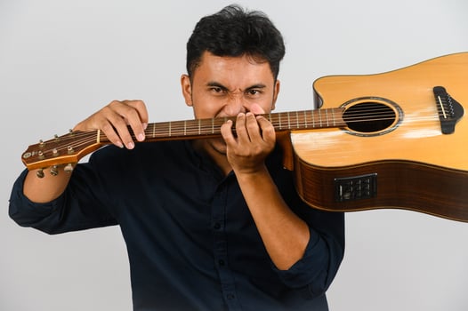 Portrait of Young Asian man playing an acoustic guitar isolated on white background photo