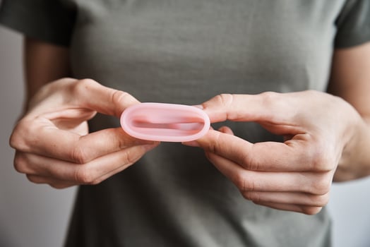 Woman holds menstrual cup in hands photo