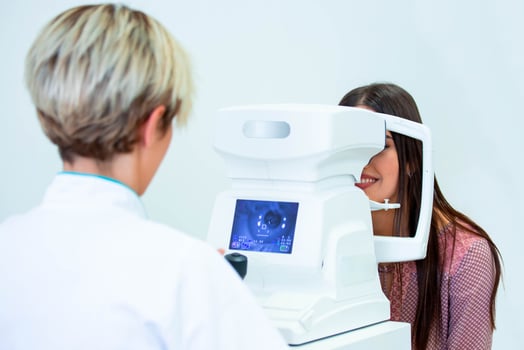 Female doctor ophthalmologist is checking the eye vision of attractive young woman in modern clinic. Doctor and patient in ophthalmology clinic. photo