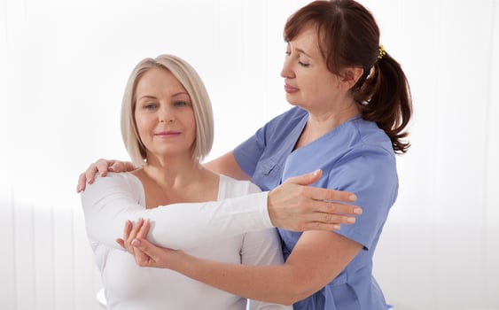 Physiotherapist working with middle aged patient in clinic photo