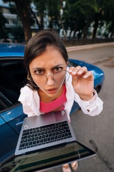 Shocked young brunette hold in hands laptop on the street photo