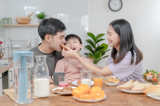 activities together during the holidays. Parents and children are having a meal together during the holidays. boy is teasing his father by giving him bread and vegetables. photo