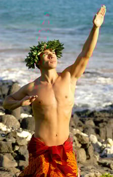 A hula dancer who is male is using his hands to gesture traditional Hawaiian symbols. photo