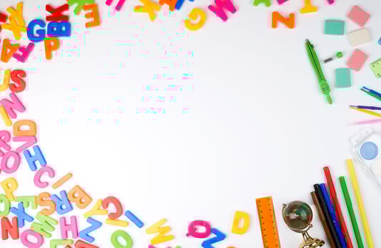 multicolored English alphabet letters and school supplieson a white background photo