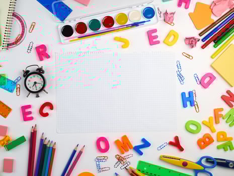 blank white squared notebook sheet and diverse school supplies photo