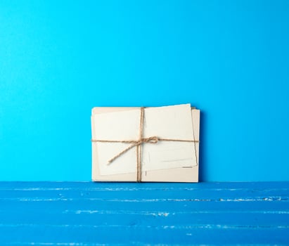 white paper cards tied with a rope on a blue wooden background photo