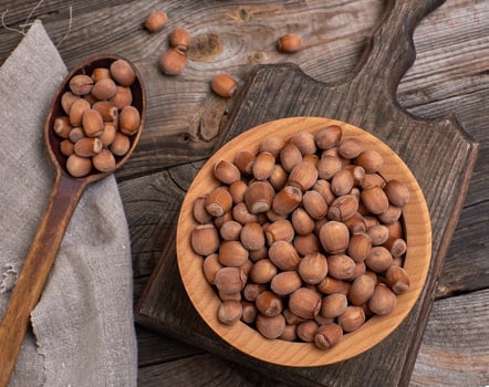 hazelnut nuts in a brown wooden bowl photo