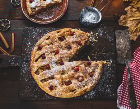 baked whole round apple pie on a rectangular old brown cutting board photo