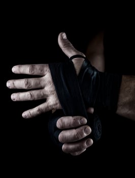 man wraps his hands in black textile bandage for sports photo