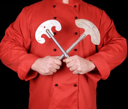 chef in red textile uniform holding old metal knives photo