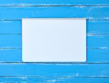 open notebook in a cell on a blue wooden background photo
