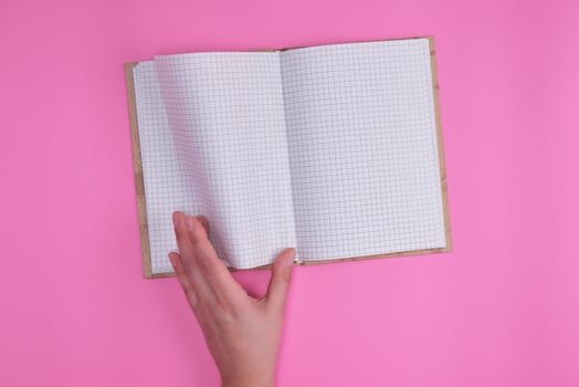 empty open notebook in a cell and a female hand photo