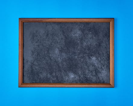 wooden empty chalk board on a blue background photo