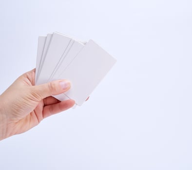 stack of empty white paper business cards in a female hand photo