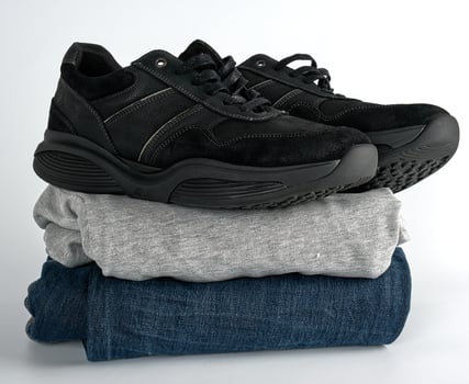stack of clothes jeans, sweater and black pair of men's shoes photo