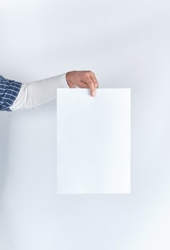 man hand holding a blank rectangular white paper sheet photo