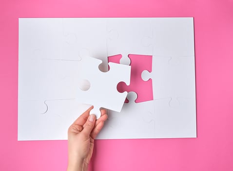 female hand puts white big puzzles photo