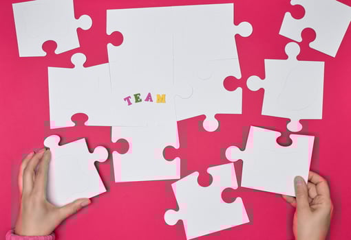 female hand puts white big puzzles on a red background photo