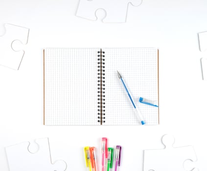 open notebook in a cell and a blue pen on a white background photo