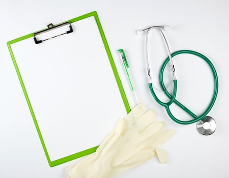 green  medical stethoscope, gloves and green paper holder photo