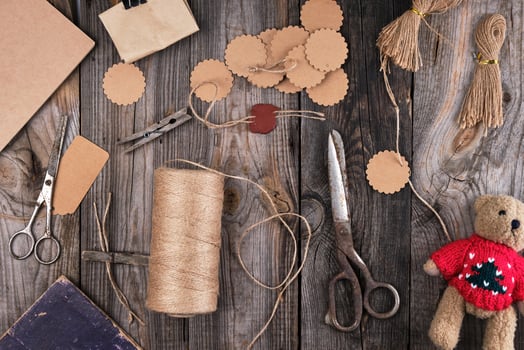 a coil of brown rope, paper tags and old scissors on a gray wooden background photo