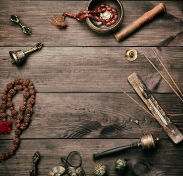 Copper singing bowl, prayer beads, prayer drum and other Tibetan religious objects for meditation photo