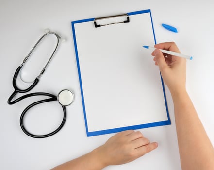 female hand holding a pen for writing a diagnosis or prescription photo