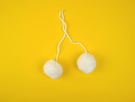 two white fluffy pom-poms of white cotton thread photo
