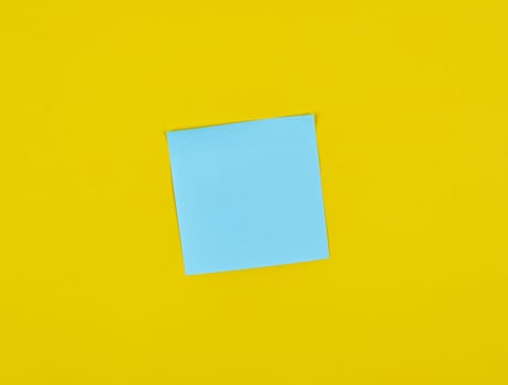 empty blue paper square stickers on yellow background photo