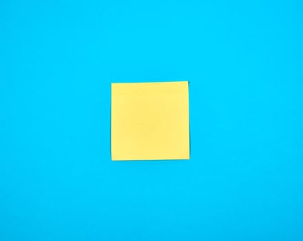 yellow empty paper square stickeron blue background photo