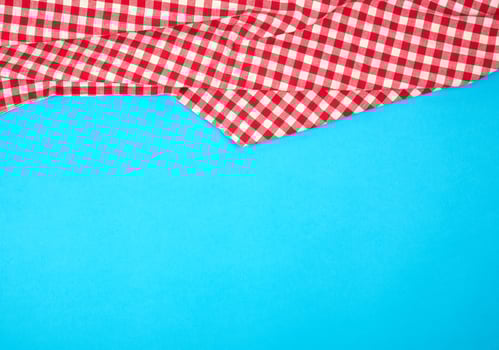 white red checkered kitchen towel on a blue background, bright picnic background photo