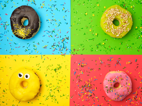 round different donuts with sprinkles on a bright multi-colored background photo