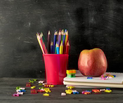 ripe red apple on a stack of notebooks photo