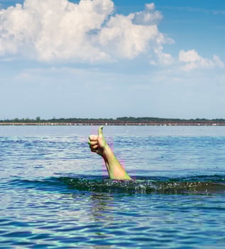 hand sticks out of the water and shows a gesture like photo