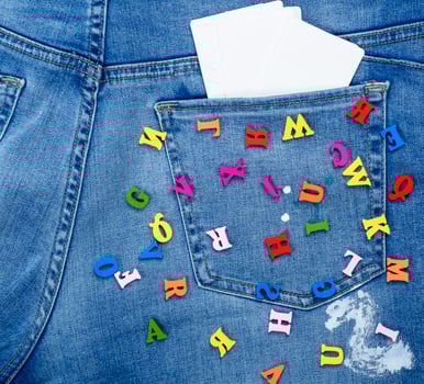 colored wooden letters scattered on blue jeans photo