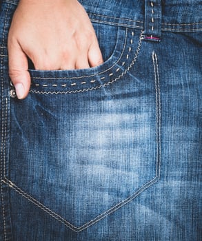 left hand stuck in the front pocket of blue jeans, full frame photo