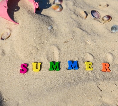 inscription summer made of wooden letters on the yellow sand photo