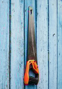 Hand saw for wood hanging from a nail photo