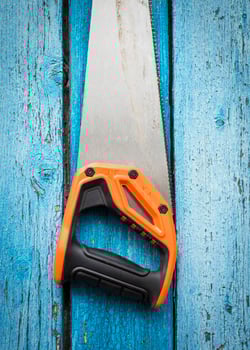 Hand saw for wood hanging from a nail photo