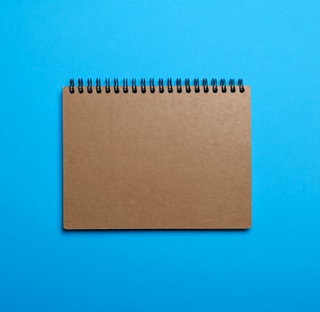 notebook on a black iron spring with brown empty sheets photo