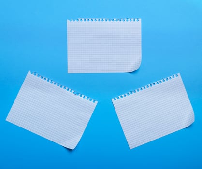 three blank sheet of paper with curved corners on a blue background, the sheets into the cell photo