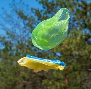 empty plastic bags fly through the green meadow photo
